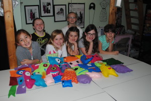 girls with colorful felt monsters they sewed