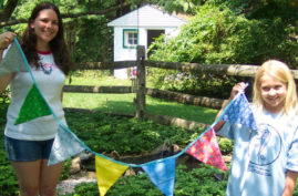2 girls holding up a handmade flag banner