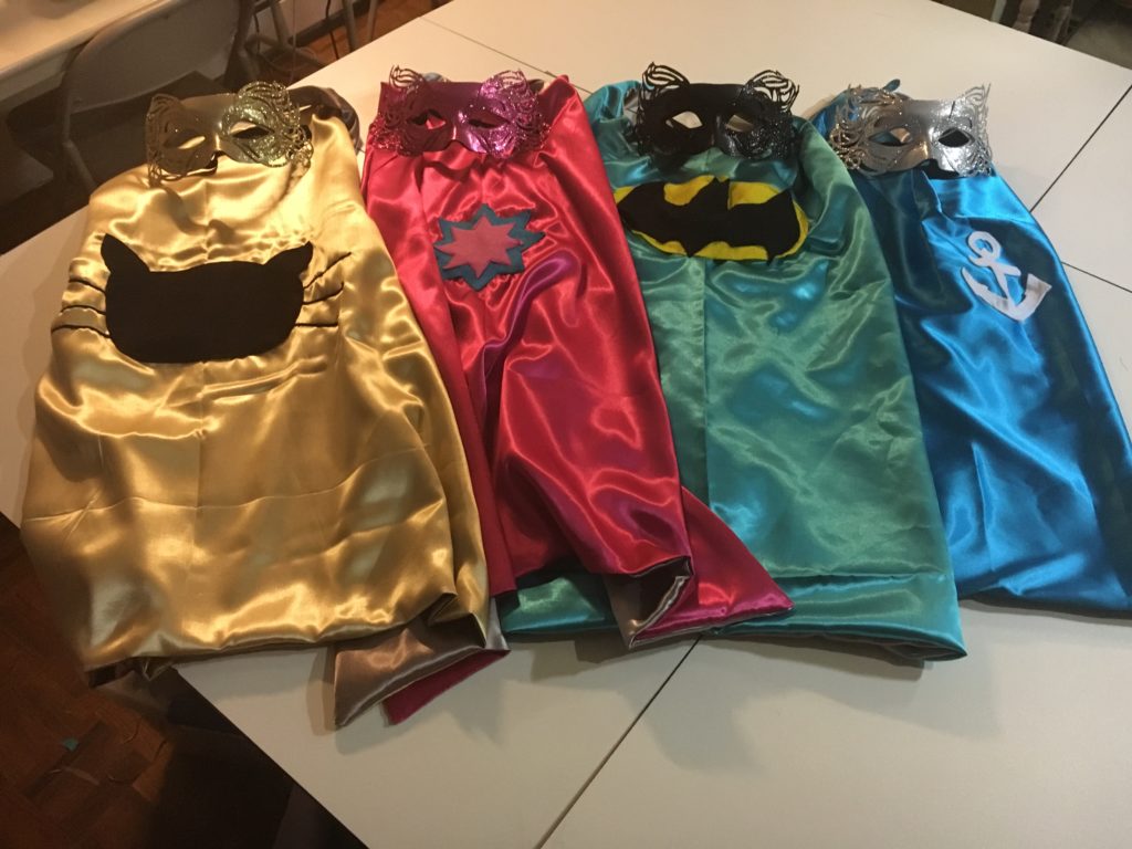 four handmade super hero capes made by sewing students