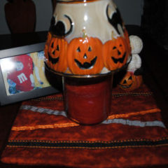 A candle on top of an easy to sew handmade Halloween placemat craft
