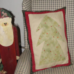 A pillow with a fabric Christmas tree