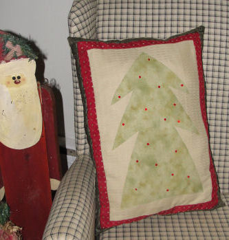 A pillow with a fabric Christmas tree