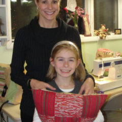 mom and daughter posing with their homemade Christmas pillow