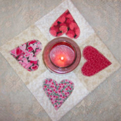 Fabric quilted with hearts for a candle mat