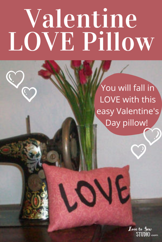 Pink fabric pillow with love written across it