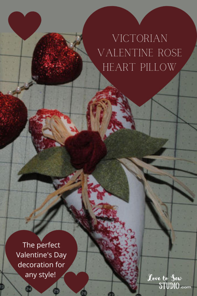 victorian fabric made into a beautiful heart pillow with a rose on the front