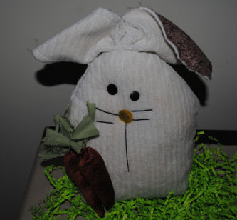 A fabric bunny with floppy ears and a carrot