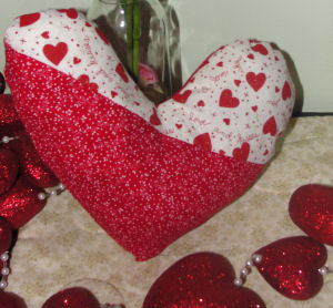 red and white valentine fabric made into a heart pillow