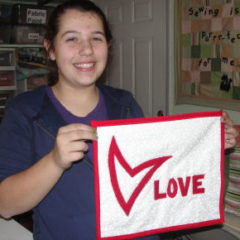 Red and white quilt with the love and a hear written on it