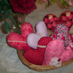 Using various valentine fabrics different pillow hearts are made and put into a basket