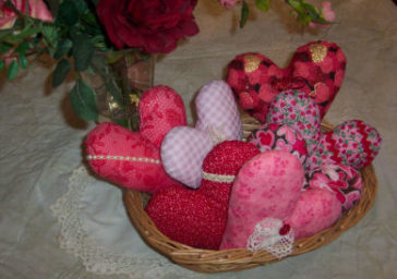 Using various valentine fabrics different pillow hearts are made and put into a basket