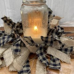 pieces of burlap and checkered fabric tied around a ring to put around a candle