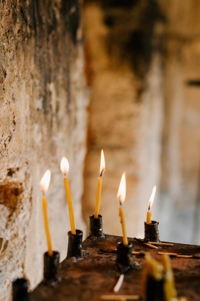 skinny candles burning in an old building
