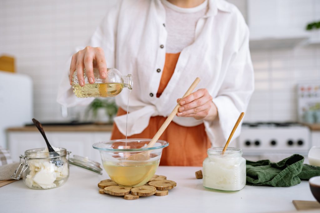 a lady pouring melted wax to make candles