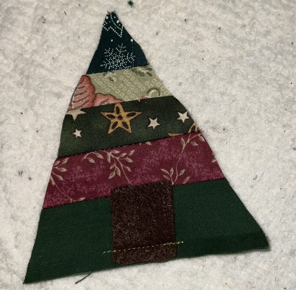 Christmas fabric made into a striped tree ornament.