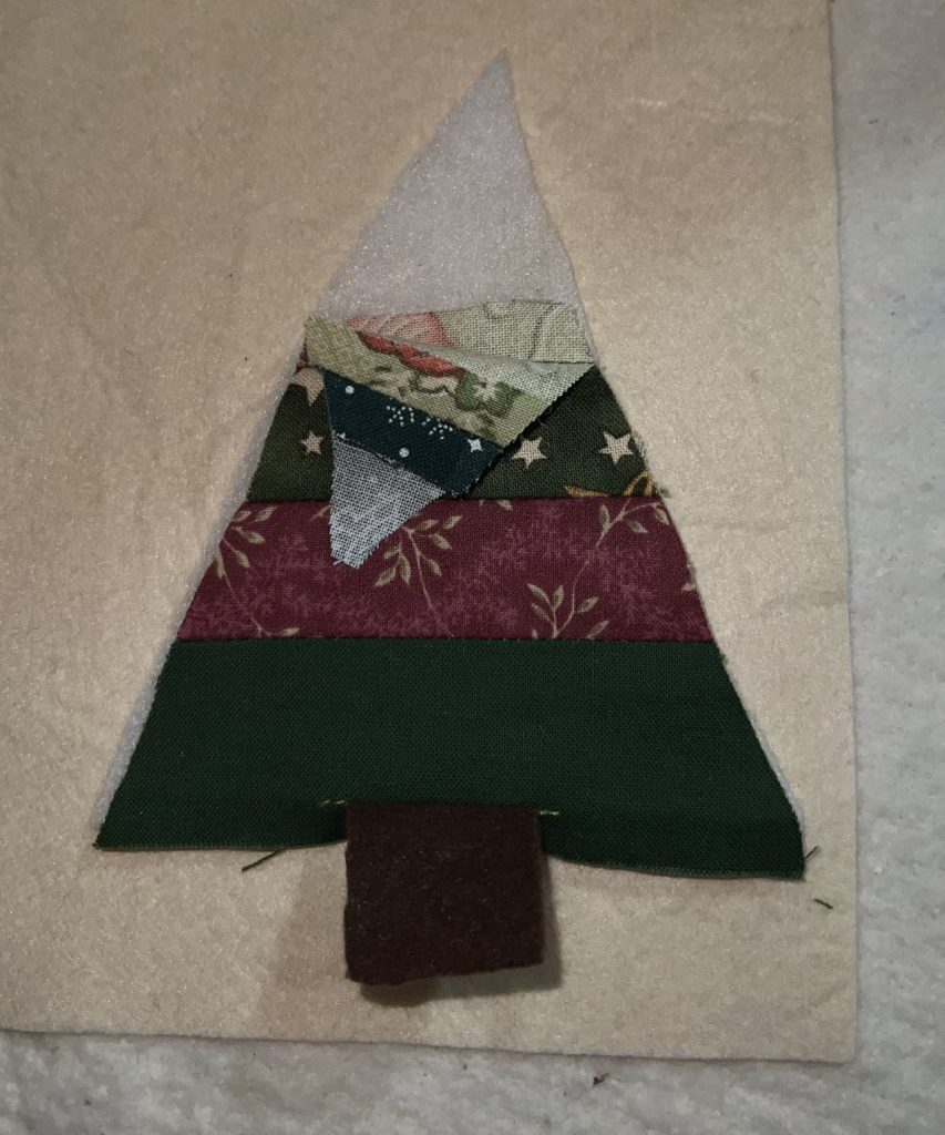 Christmas fabric made into a striped tree ornament.
