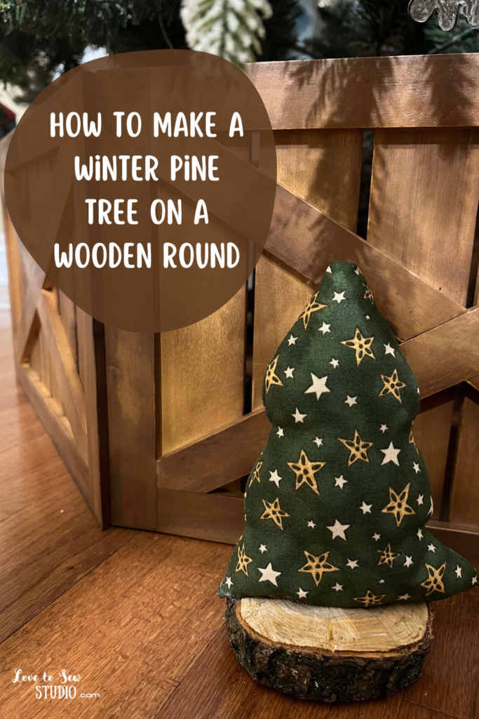 fabric made into a winter tree and placed on a wooden round